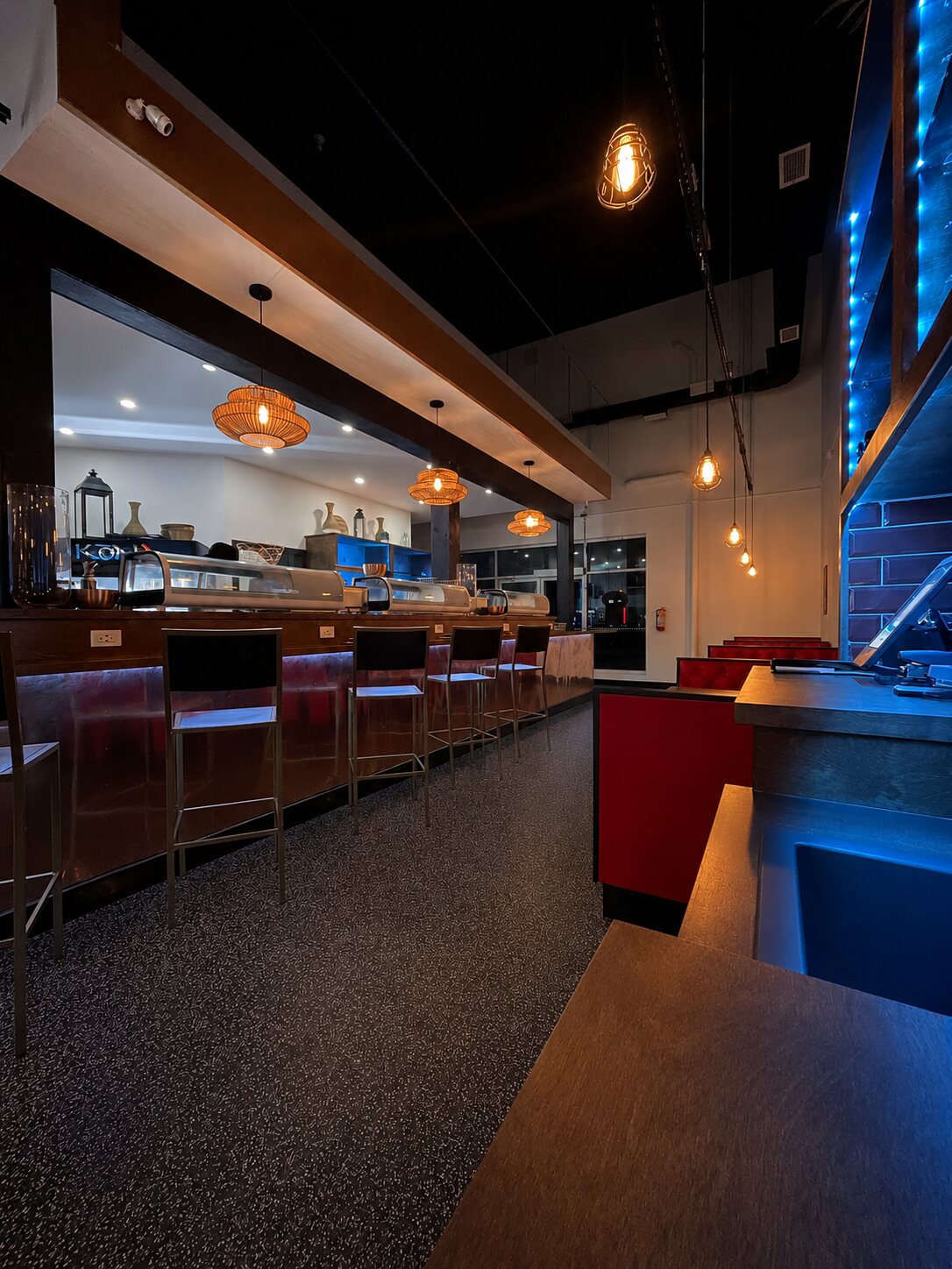 The sushi bar washed in cool blue LED accent light for an evening mood.