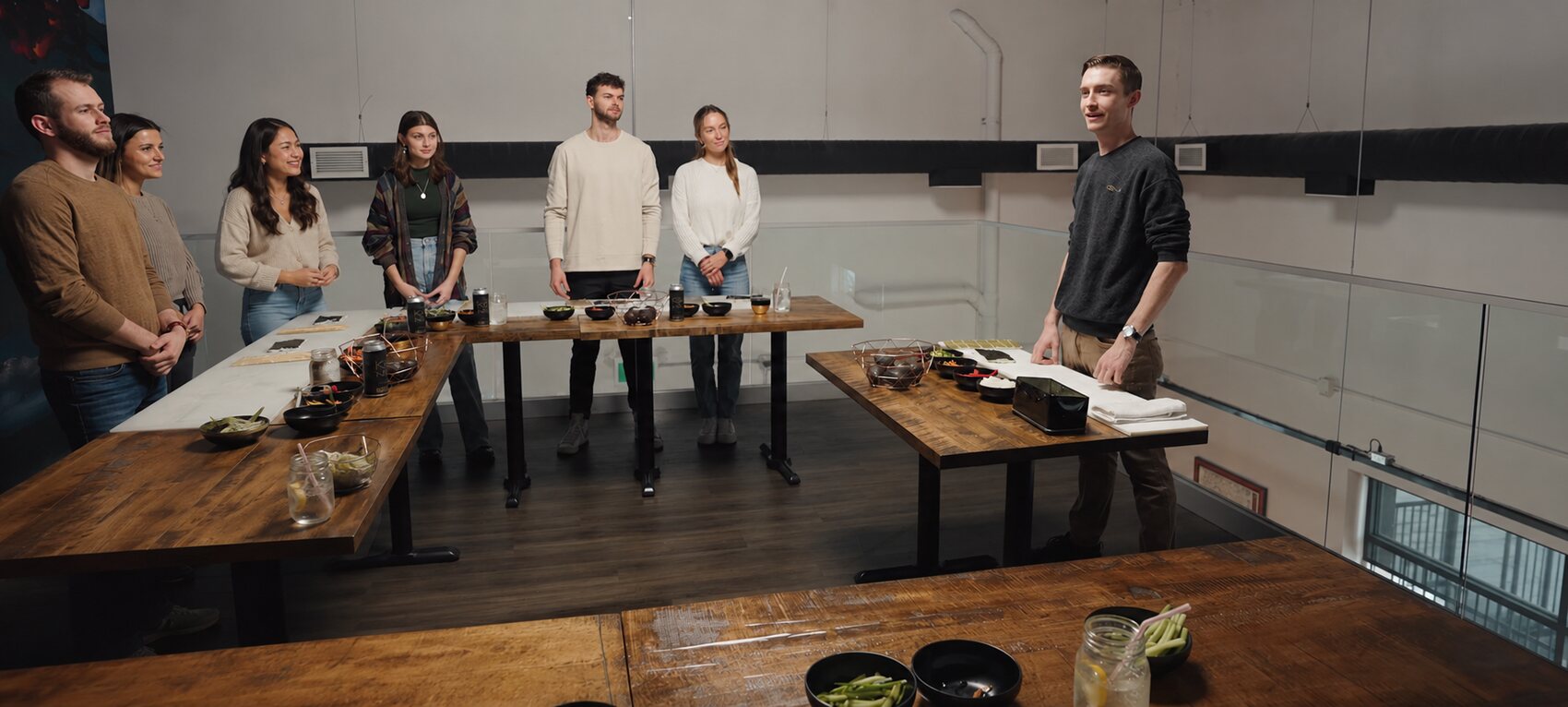 A sushi masterclass group gathered with their instructor at the mezzanine tables.