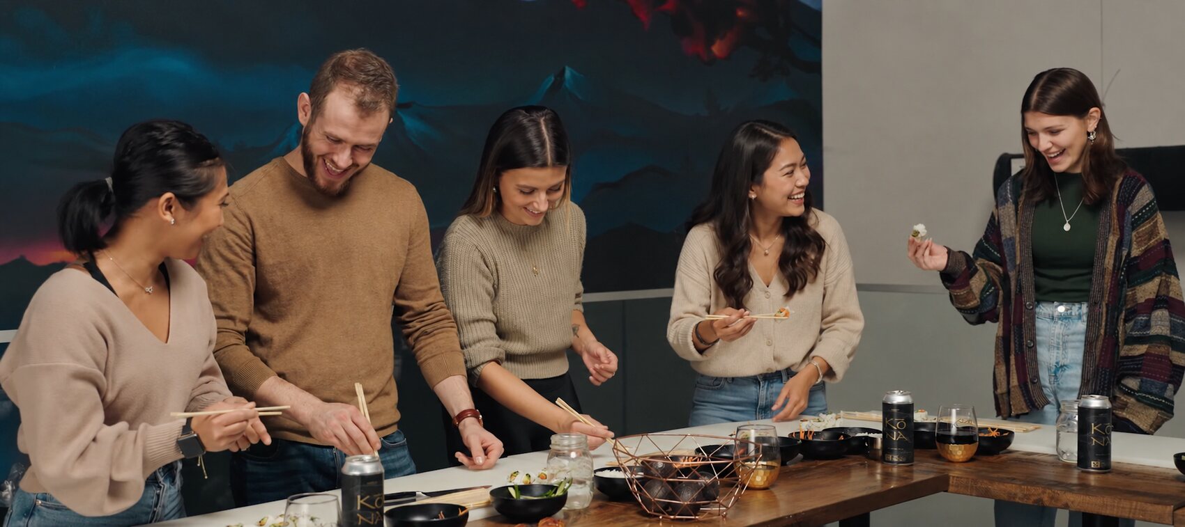Guests at a hands-on Kōna sushi masterclass, laughing as they roll their own sushi at the mezzanine tables.