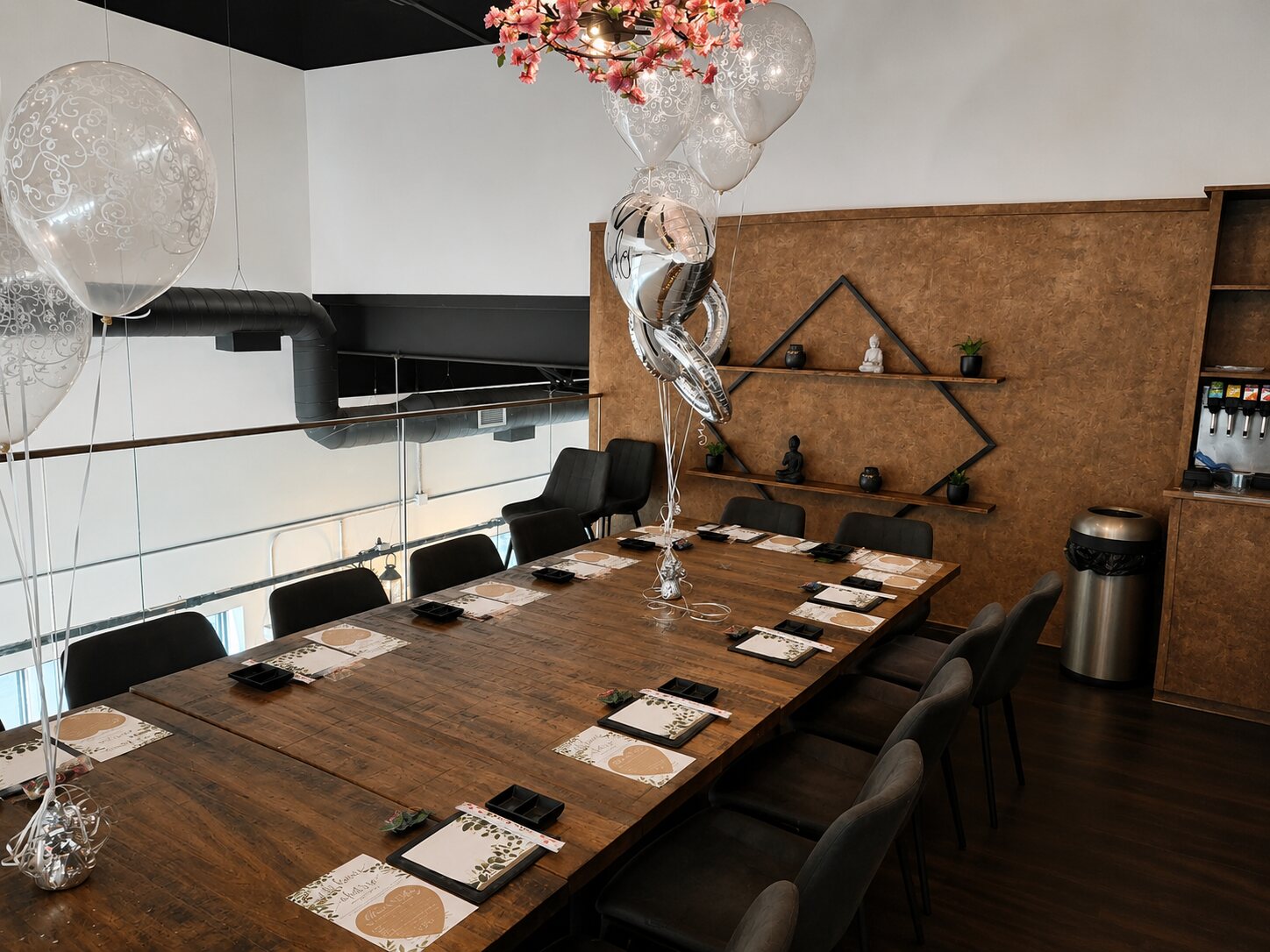The private mezzanine event space set for a party — a long table, place settings and balloons, ready for a private booking.