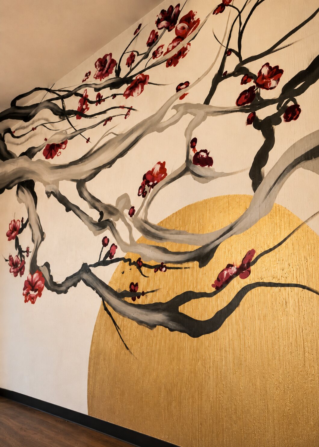 An ink-brush mural of cherry blossom branches over a golden sun, elegant and serene.