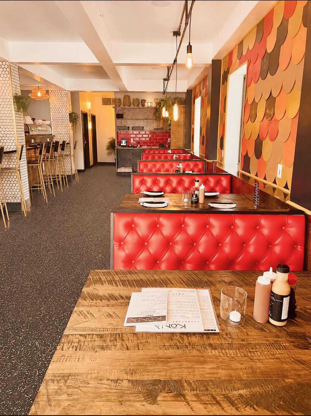 Bar seating along the front window, afternoon light catching a honeycomb-tiled column.