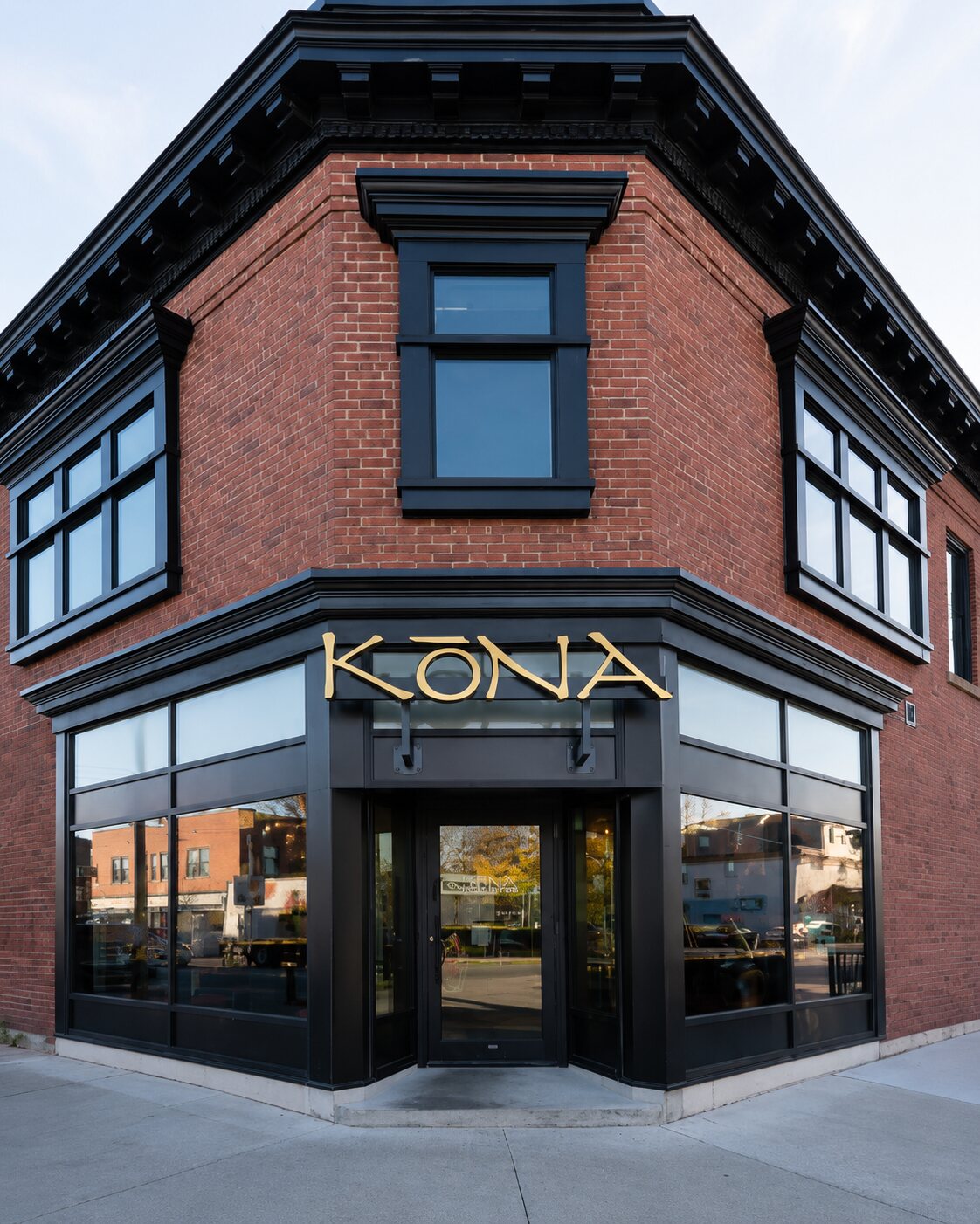 Kōna Walkerville's historic corner brick building with black trim and gold KŌNA lettering above the corner entrance.