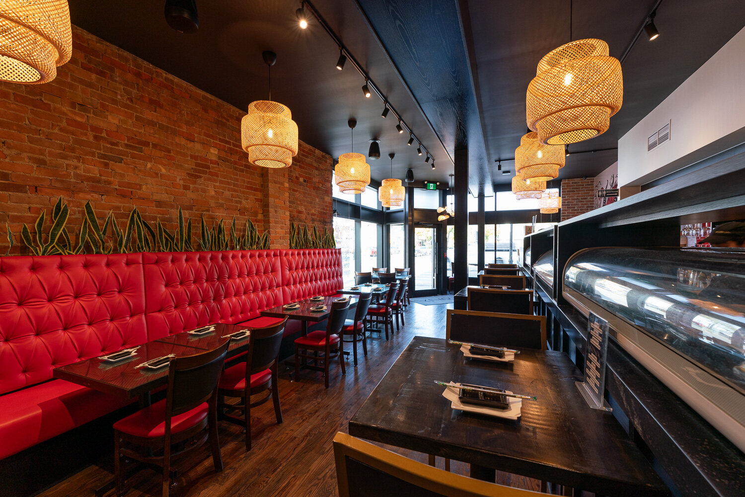 The sushi bar and display cases with gold bar stools, looking toward the front windows.