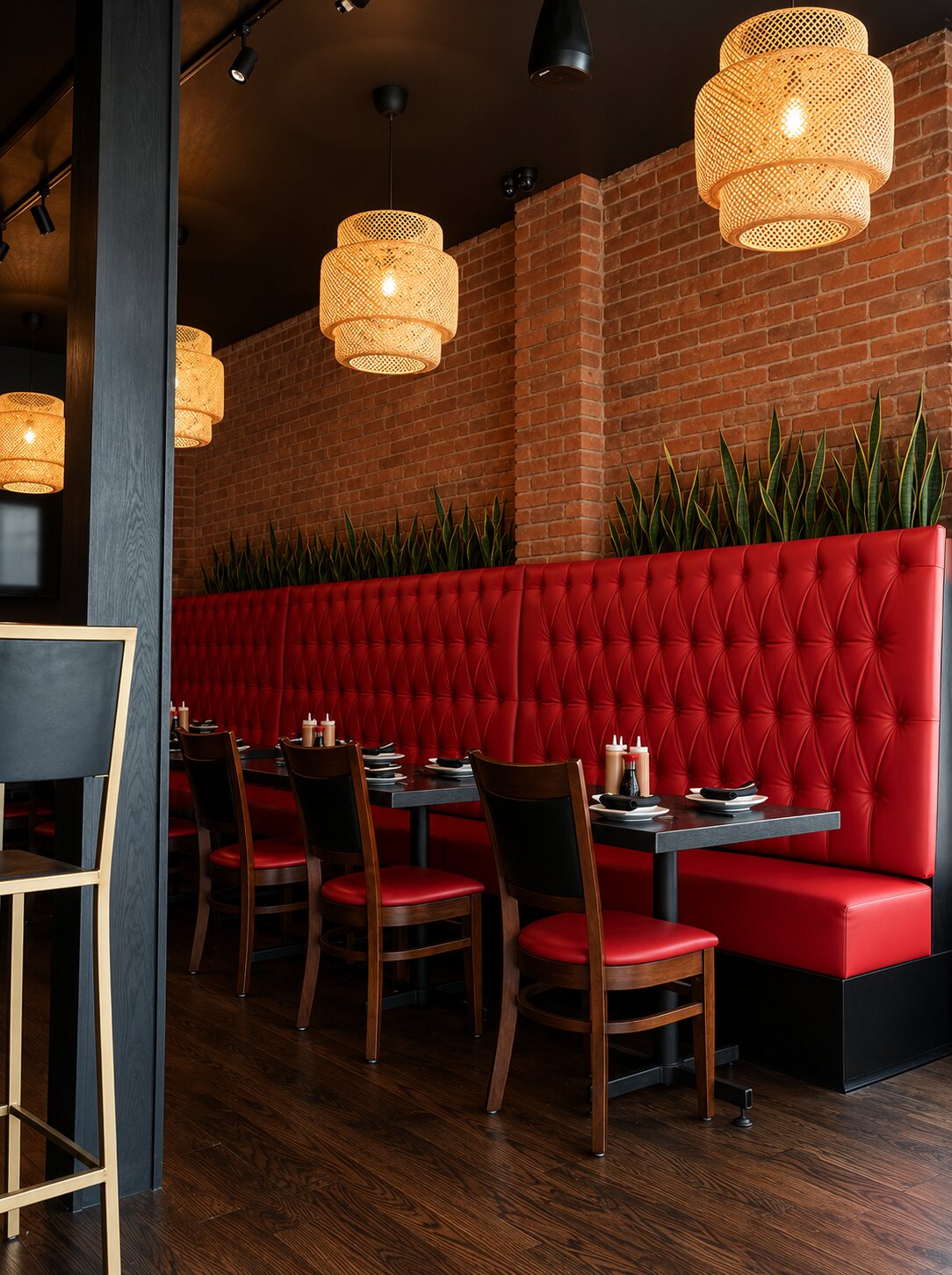 Wide view of the dining room — the dragon mural at one end, the bar, red banquettes and rattan pendants.